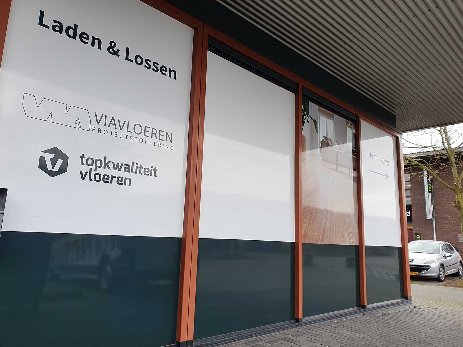 Raambestickering in huisstijlkleuren afgewerkt met een hoogglans laminaat voor een duurzaam resultaat